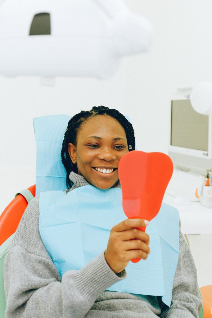 patient looking in mirror at her aesthetic smile realigning happy with the legal aspects of her surgery