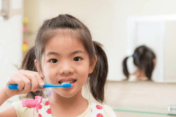 young girl brushing teeth focusing on children's oral hygiene